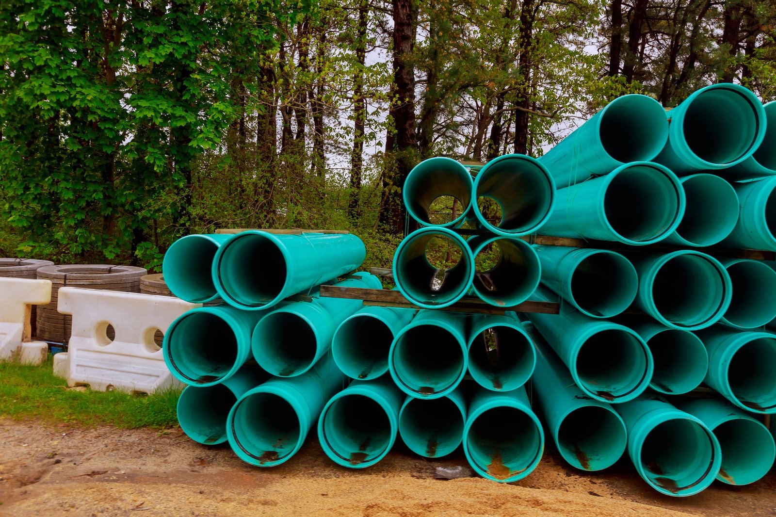 Pallets of green sewer PVC pipes at construction for drainage system